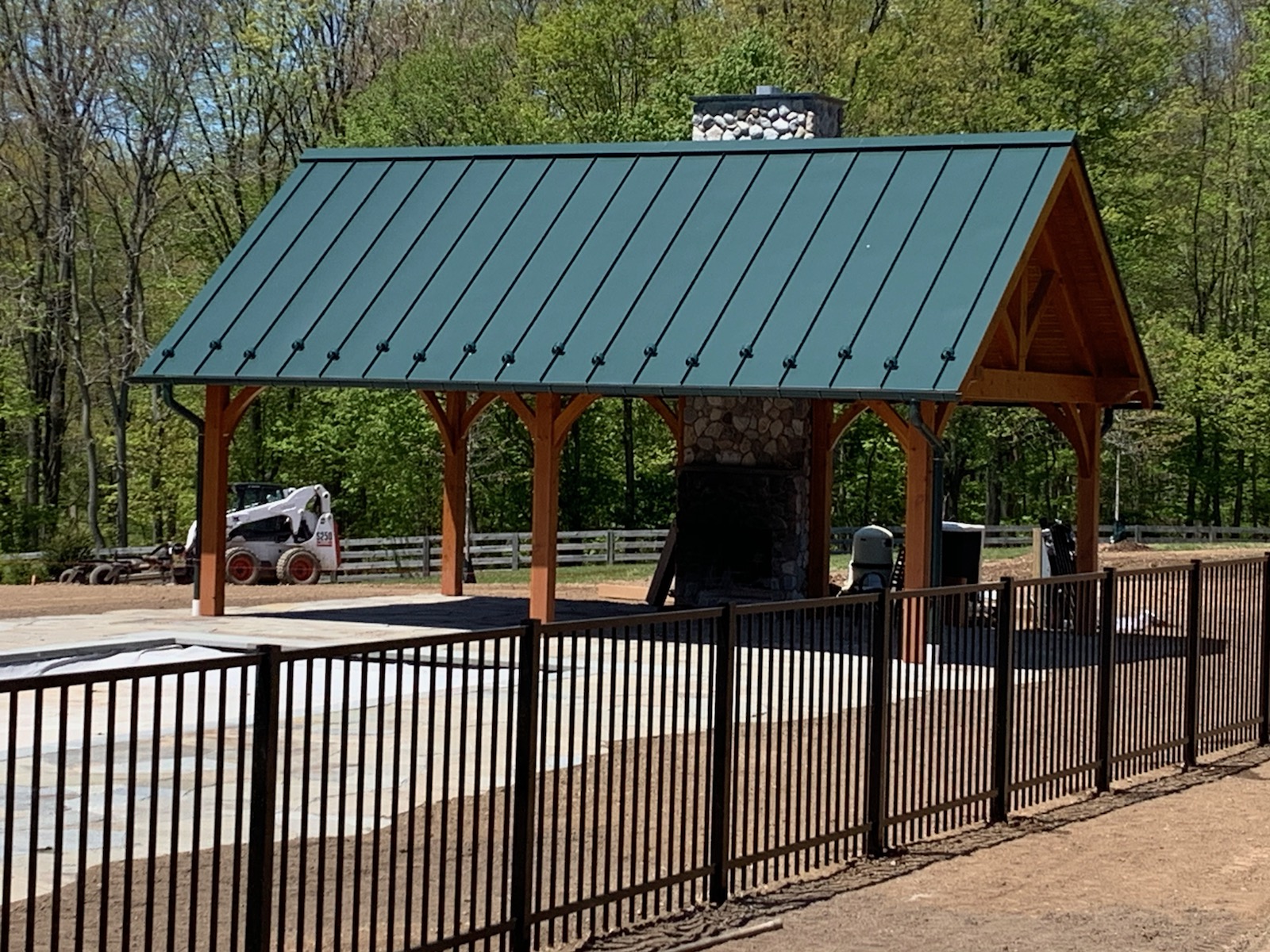 Pool-code ornamental fence installed beside a timber pavilion
