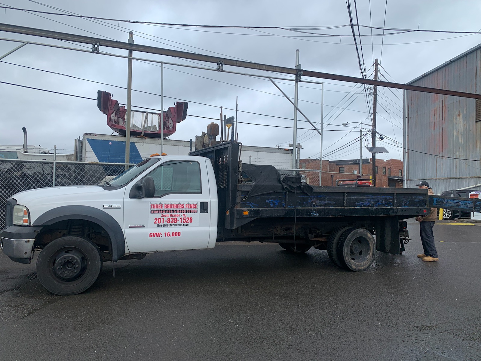 Three Brothers Fence Co. branded work truck loaded with fencing materials