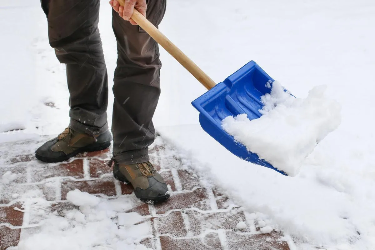 Shovelling snow clear of a brick walkway during a New Jersey winter
